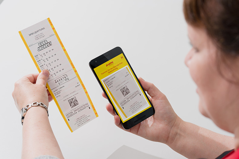 Frau scannt Spielquittung mit Lotto Baden-Württemberg App